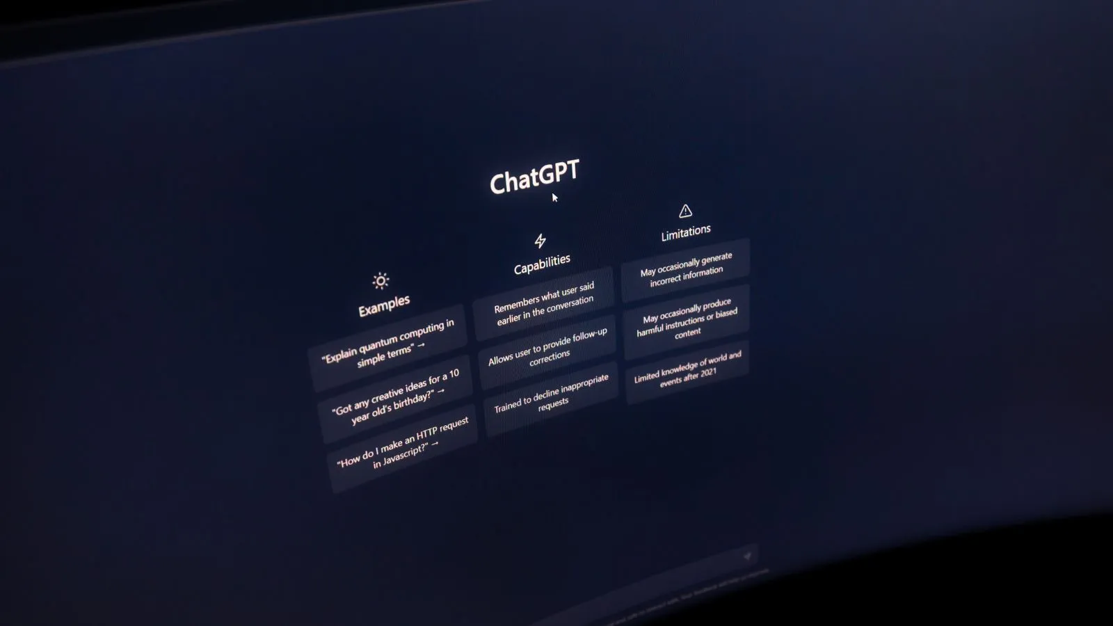 A computer monitor showing an AI chat assistant's start screen, with example questions listed under headings for examples, capabilities, and limitations.